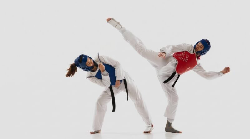Two AAU Taekwondo competitors sparring at a sanctioned tournament, illustrating AAU Taekwondo membership requirements