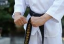 Taekwondo practitioner wearing a black belt demonstrating a high kick during training