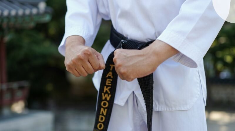 How Long Does It Take to Get a Black Belt in Taekwondo? | Dan Ranks Explained Taekwondo practitioner wearing a black belt demonstrating a high kick during training